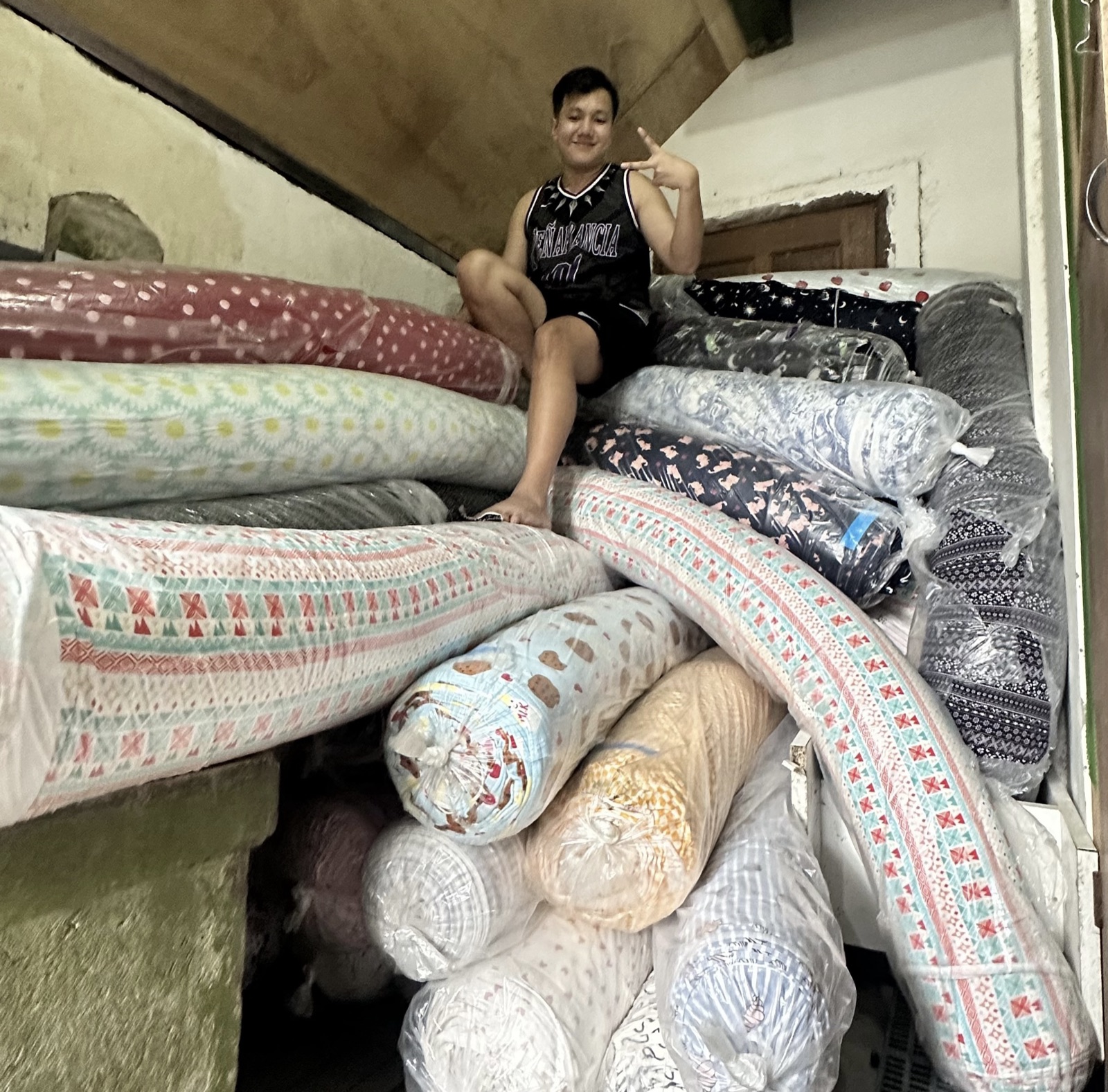 Jerome among rolls of fabric at the family business