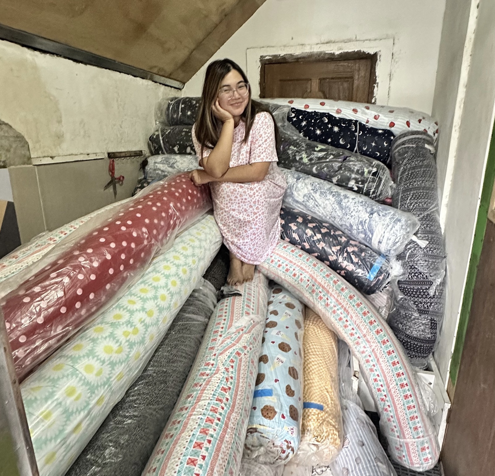 Alex among rolls of fabric at the family business
